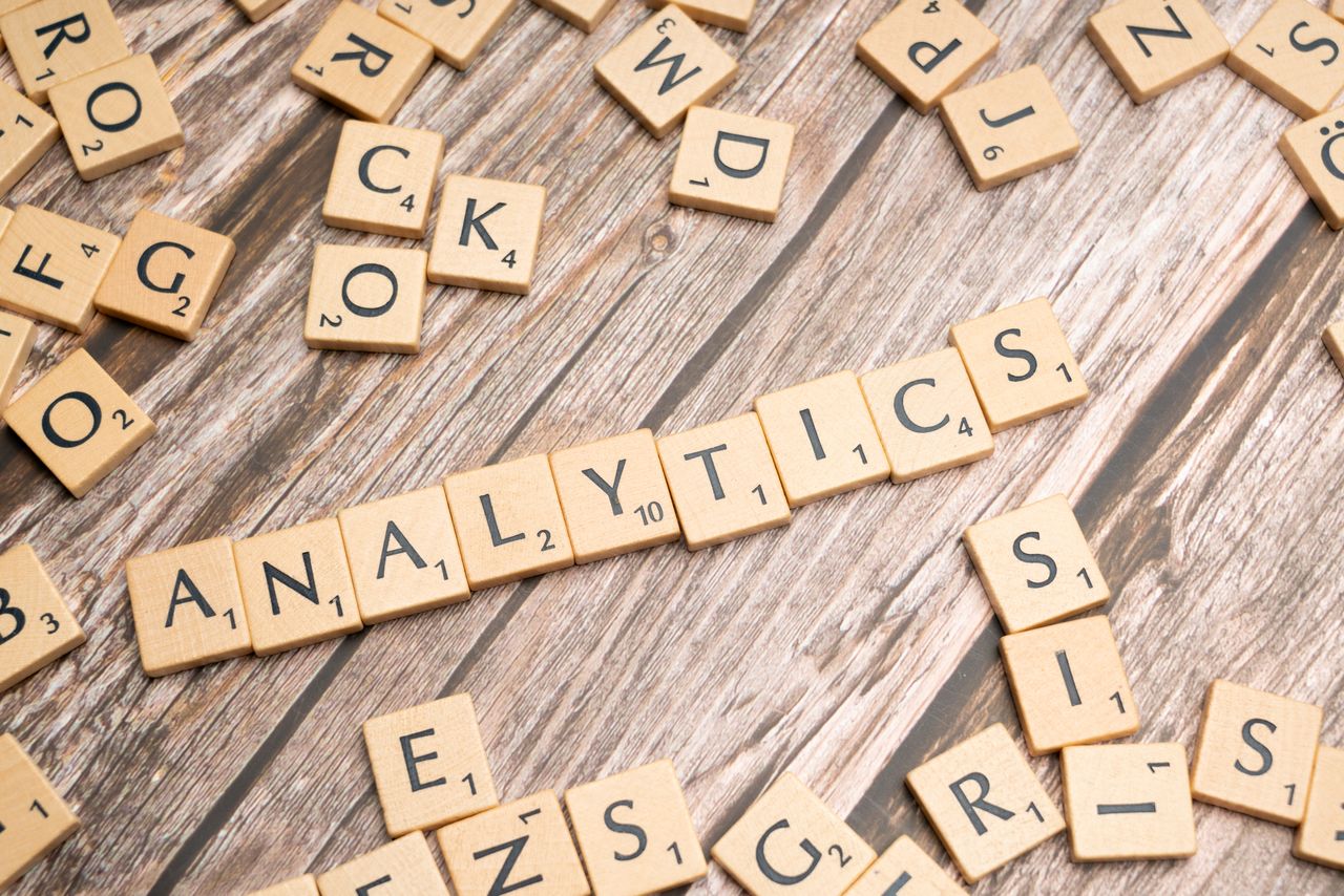 services-03 Scrabble tiles spelling Analytics on a wooden surface, symbolizing data analytics concept.